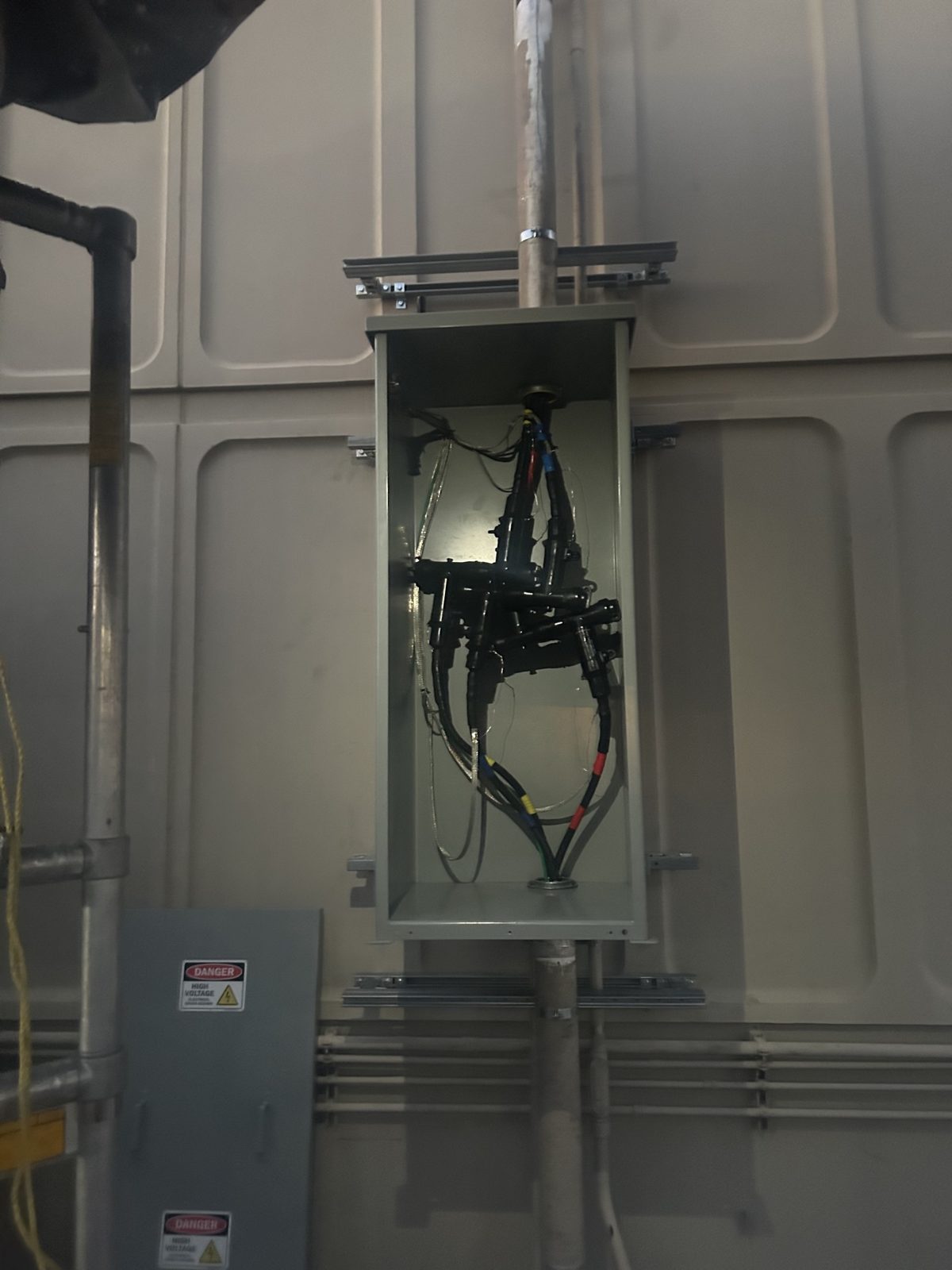 Medium-voltage loadbreak elbows racked and seated inside the cabinet, with phases marked and grounds landed.